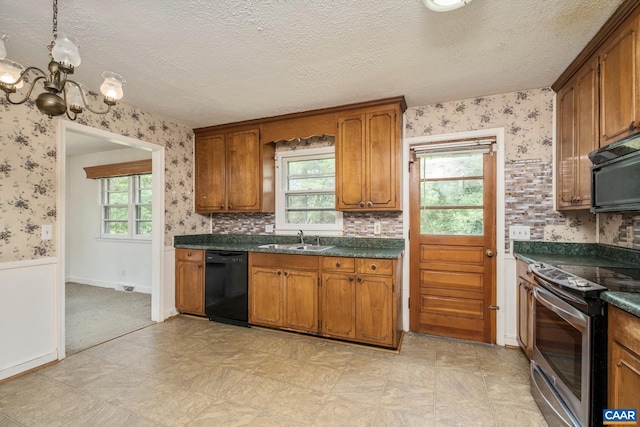 kitchen featuring sink, a notable chandelier, black appliances, and a textured ceiling