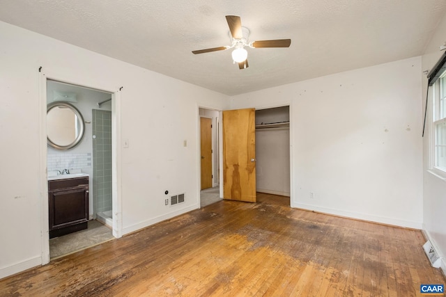 unfurnished bedroom with dark wood-type flooring, sink, a closet, and a textured ceiling