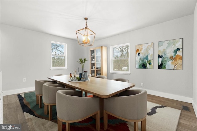 dining area featuring dark hardwood / wood-style floors and a chandelier