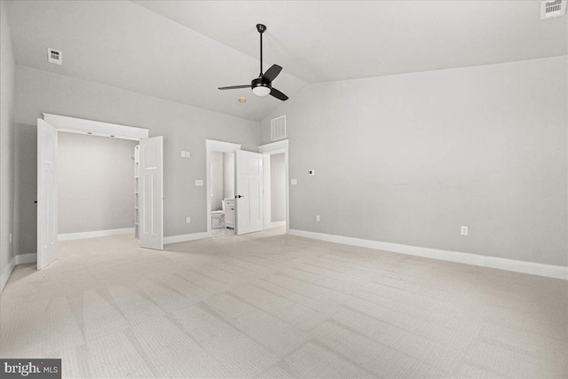 unfurnished bedroom with ensuite bathroom, a spacious closet, light colored carpet, ceiling fan, and a closet