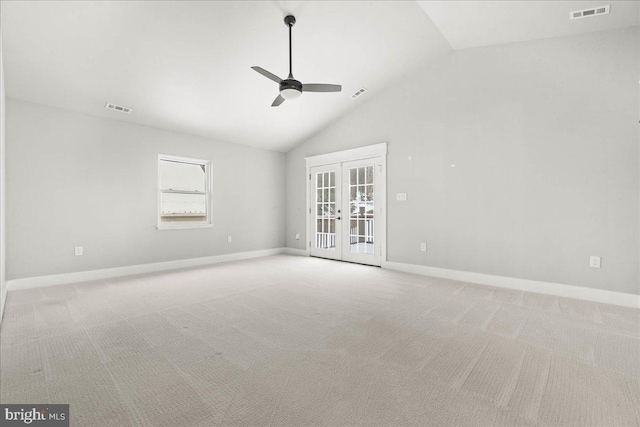 carpeted empty room with high vaulted ceiling, ceiling fan, and french doors