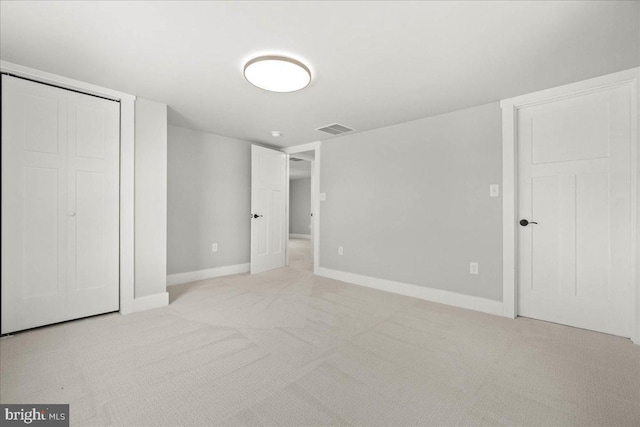 unfurnished bedroom featuring a closet and light carpet