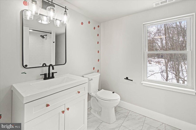 bathroom featuring plenty of natural light, toilet, and vanity