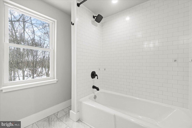 bathroom with a healthy amount of sunlight and tiled shower / bath combo