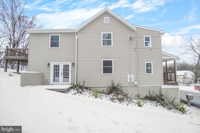 snow covered property with french doors