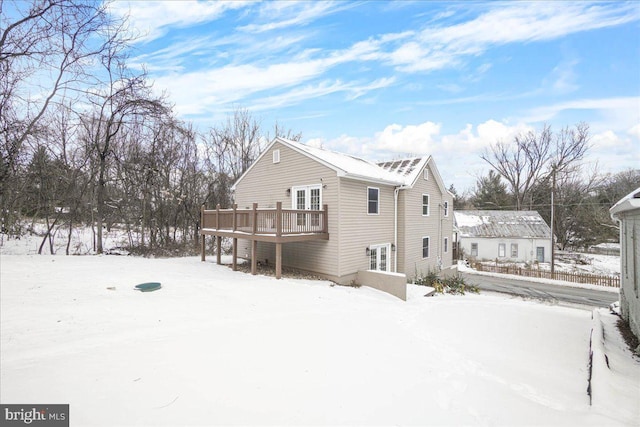 snow covered house with a deck