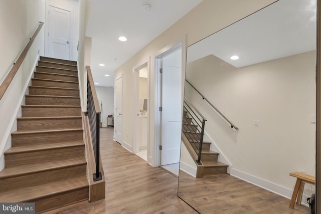 staircase with hardwood / wood-style floors