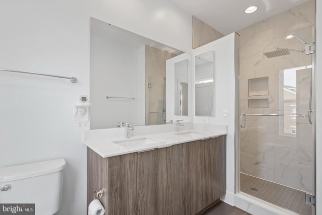 bathroom with walk in shower, vanity, and toilet