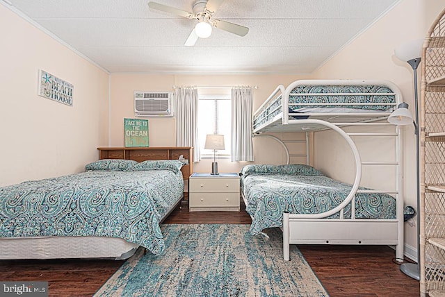 bedroom featuring a wall mounted air conditioner, a textured ceiling, ornamental molding, dark hardwood / wood-style flooring, and ceiling fan