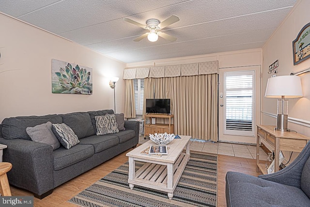 living room with crown molding, ceiling fan, and light hardwood / wood-style floors