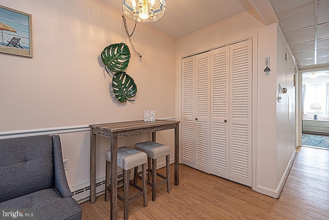 dining room with crown molding and light hardwood / wood-style flooring