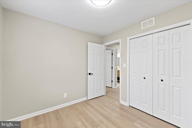 unfurnished bedroom featuring light hardwood / wood-style floors and a closet