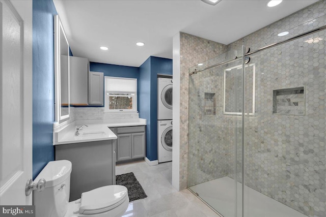 bathroom featuring stacked washer / dryer, vanity, tasteful backsplash, toilet, and walk in shower