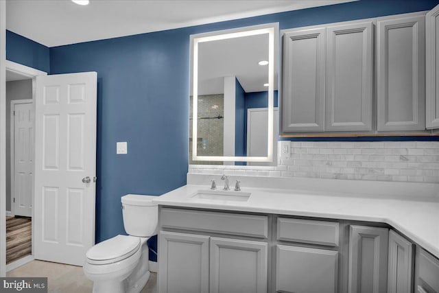 bathroom with tasteful backsplash, vanity, and toilet