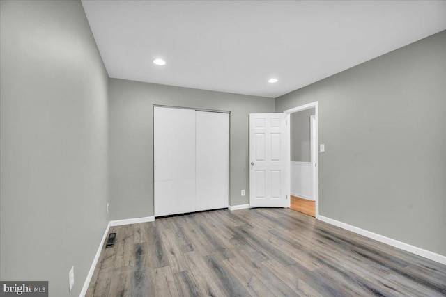 unfurnished bedroom with hardwood / wood-style flooring and a closet