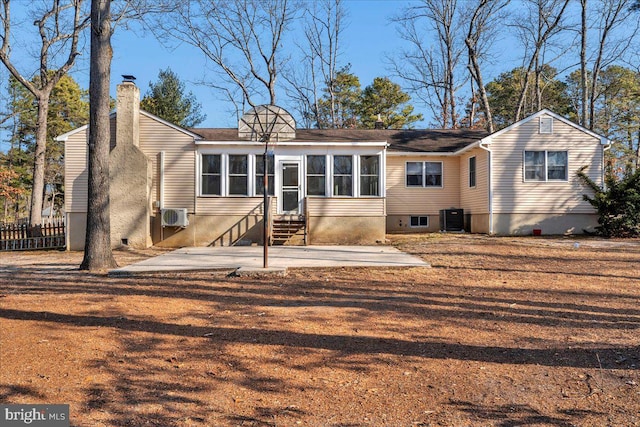 rear view of property with a sunroom, central AC unit, and a patio area