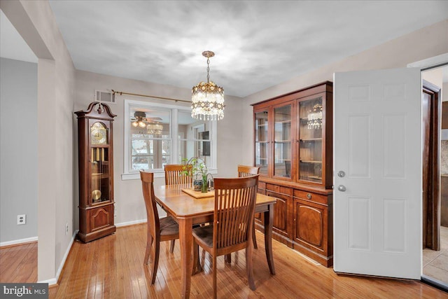 dining area with a notable chandelier and light wood-type flooring