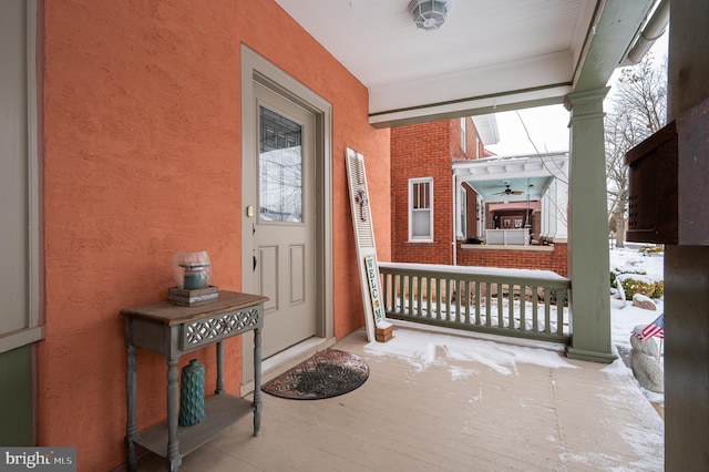 snow covered property entrance featuring covered porch