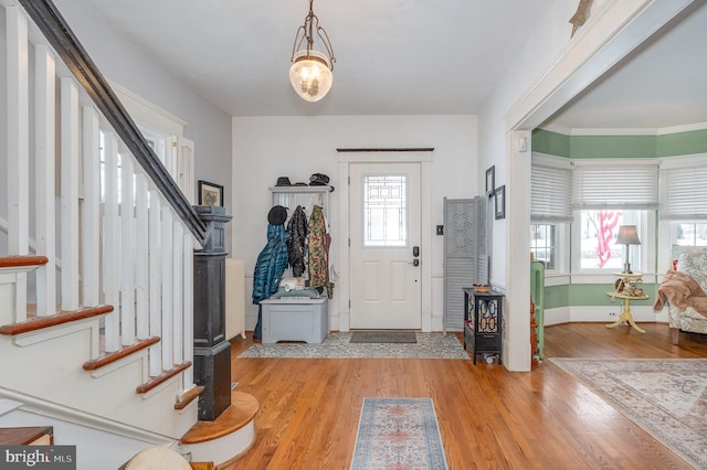 entrance foyer featuring crown molding, hardwood / wood-style floors, and a wealth of natural light