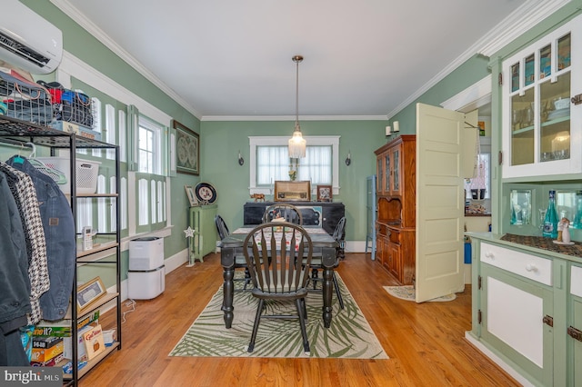 dining room featuring crown molding, light hardwood / wood-style floors, and a wall unit AC