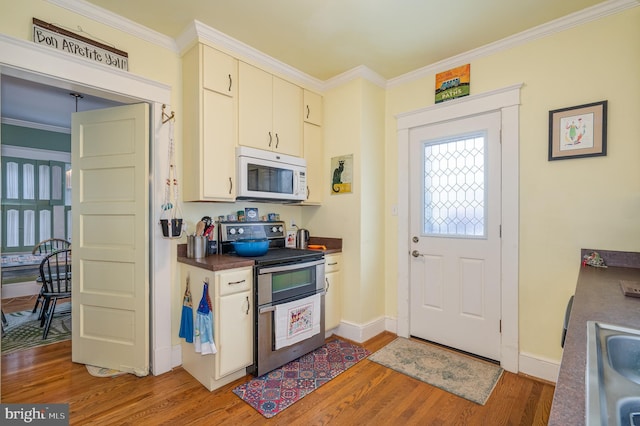 kitchen featuring crown molding, double oven range, sink, and wood-type flooring