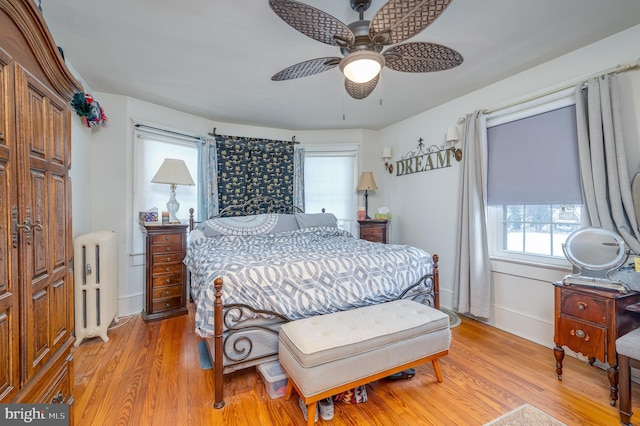 bedroom with radiator, ceiling fan, and light wood-type flooring