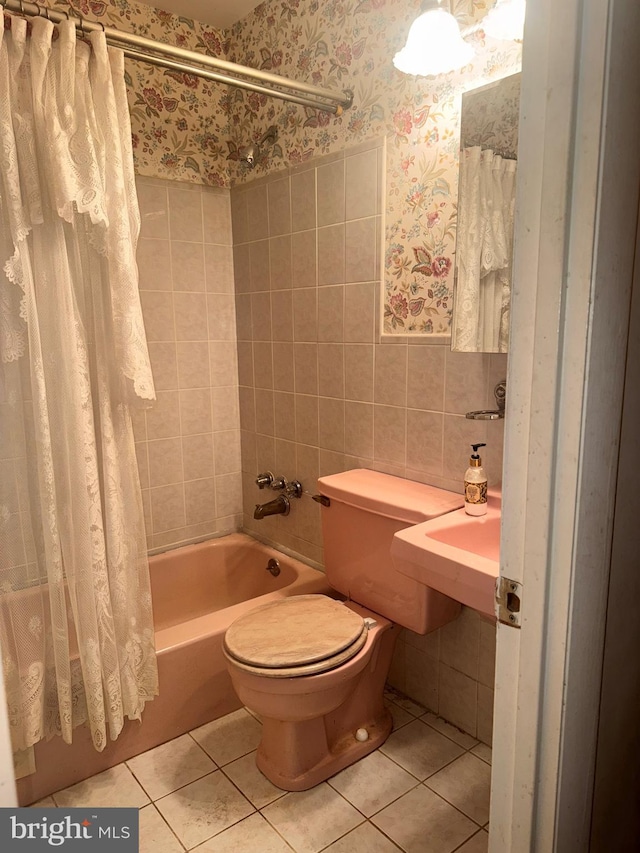 bathroom featuring tile patterned flooring, toilet, tile walls, and shower / bath combo with shower curtain