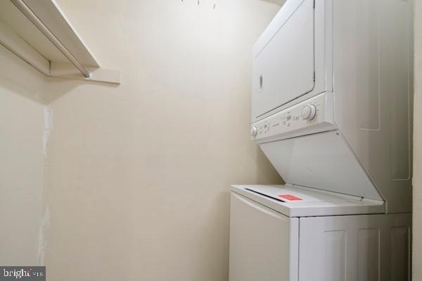 clothes washing area with stacked washer / dryer