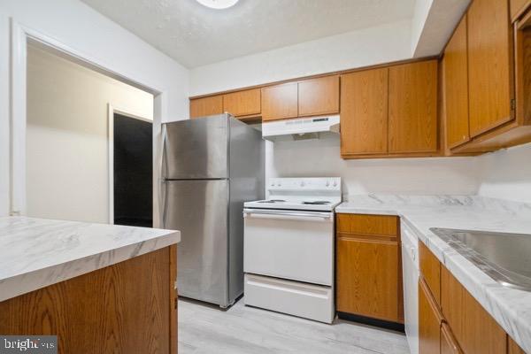 kitchen featuring sink, white appliances, and light hardwood / wood-style flooring