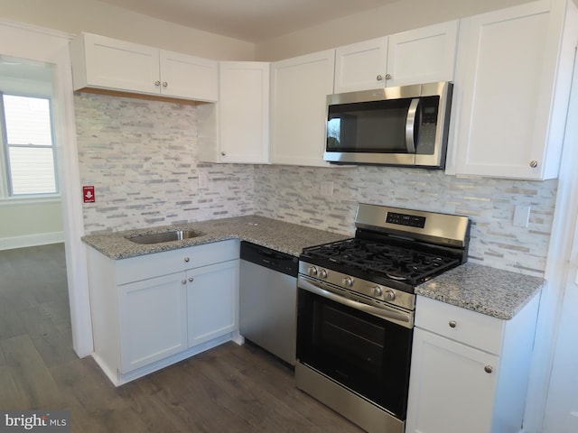 kitchen with white cabinetry, light stone counters, tasteful backsplash, and stainless steel appliances