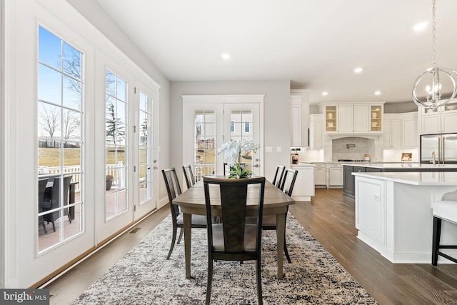 dining area with a notable chandelier and dark hardwood / wood-style floors