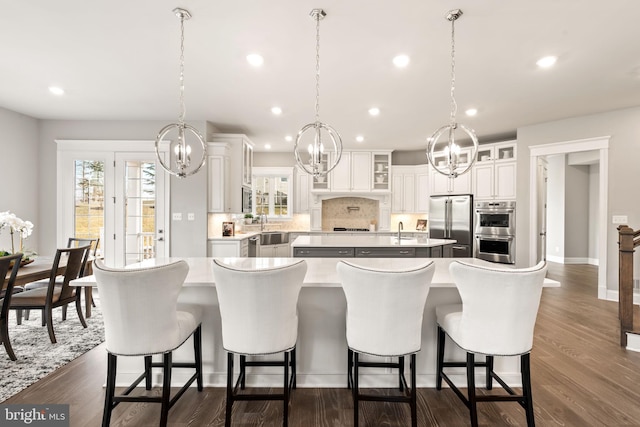 kitchen with hanging light fixtures, stainless steel appliances, a breakfast bar area, and a large island