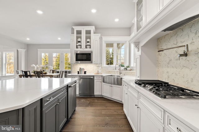 kitchen featuring sink, appliances with stainless steel finishes, white cabinets, and a wealth of natural light