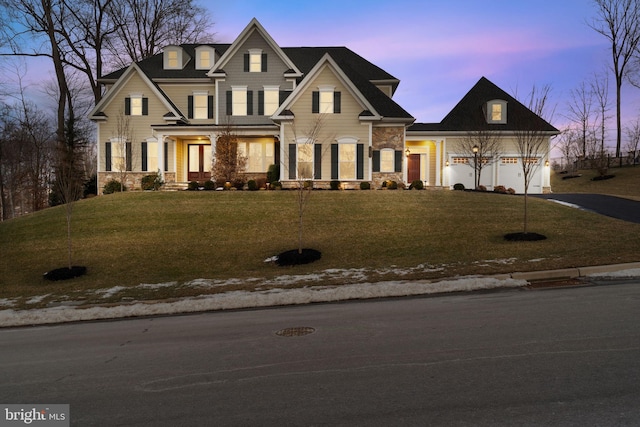 craftsman-style house featuring a garage and a lawn