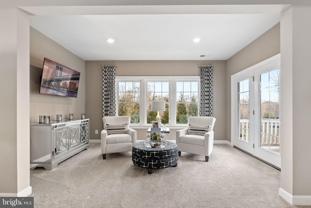 living area with light colored carpet and a wealth of natural light