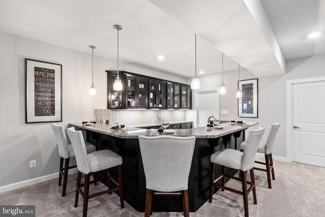 bar with backsplash, carpet floors, and decorative light fixtures