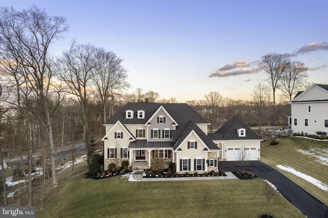 view of front of property featuring a lawn, a garage, and a porch