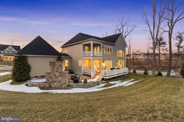 exterior space featuring a lawn, a deck, and a balcony