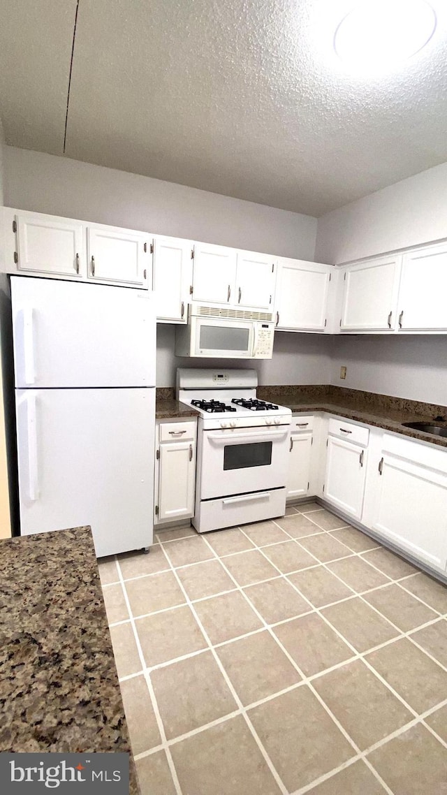 kitchen featuring white cabinetry, white appliances, and light tile patterned flooring