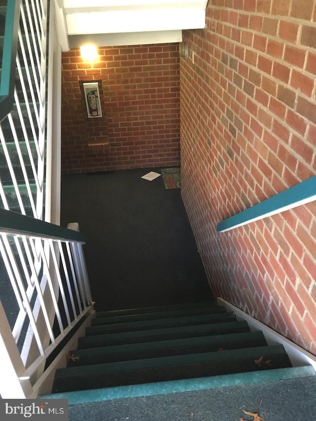 stairs featuring brick wall