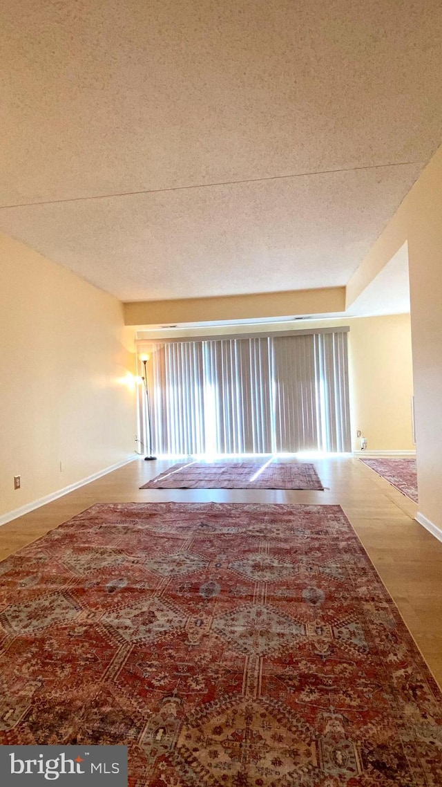 spare room featuring hardwood / wood-style floors and a textured ceiling