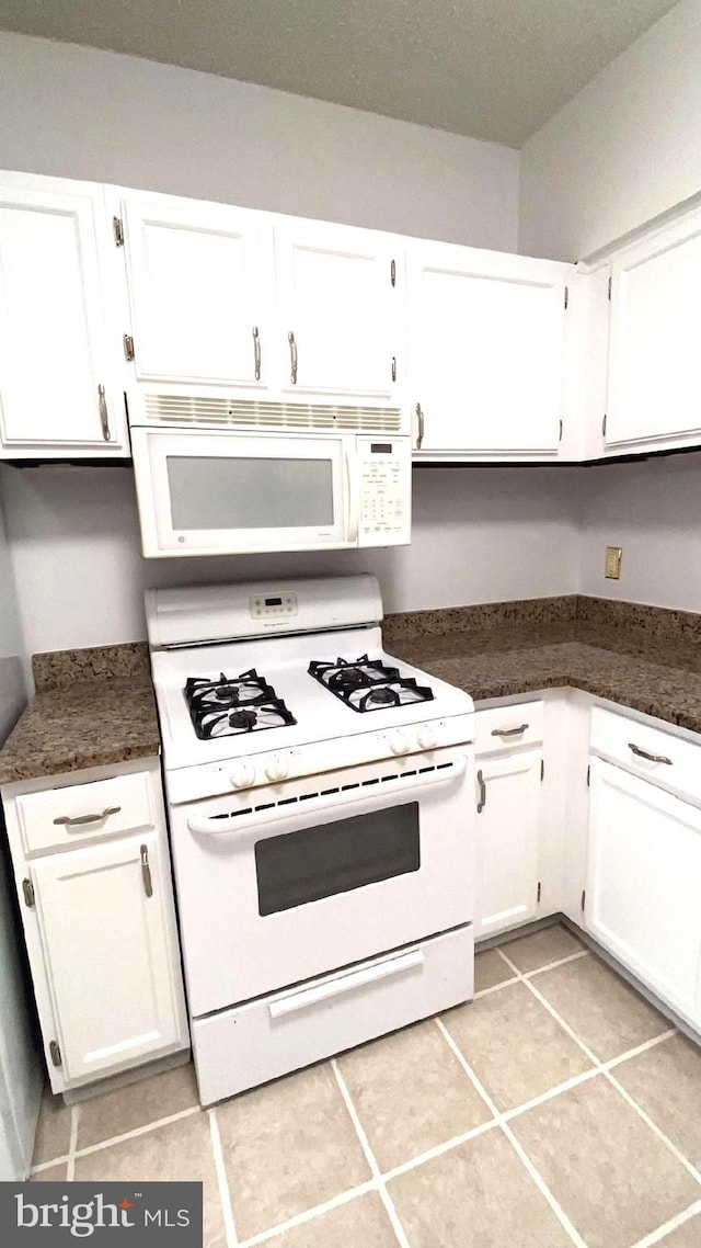 kitchen featuring white cabinetry, white appliances, and light tile patterned floors