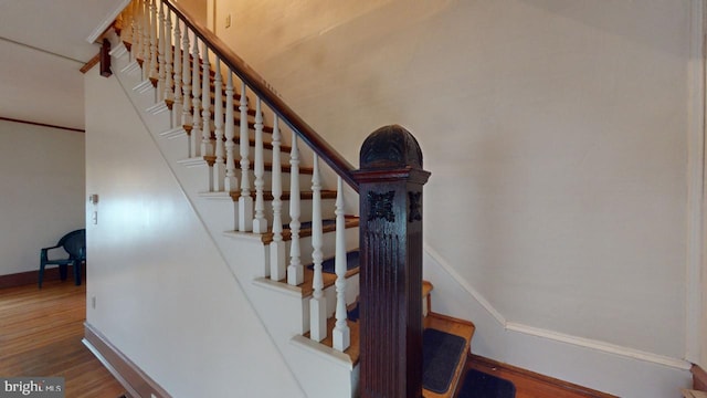 stairs featuring hardwood / wood-style floors