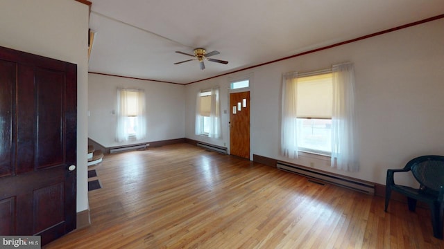 entryway with ornamental molding, a wealth of natural light, light wood-type flooring, and a baseboard heating unit