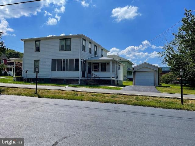 view of front facade with a garage, an outbuilding, and a front lawn