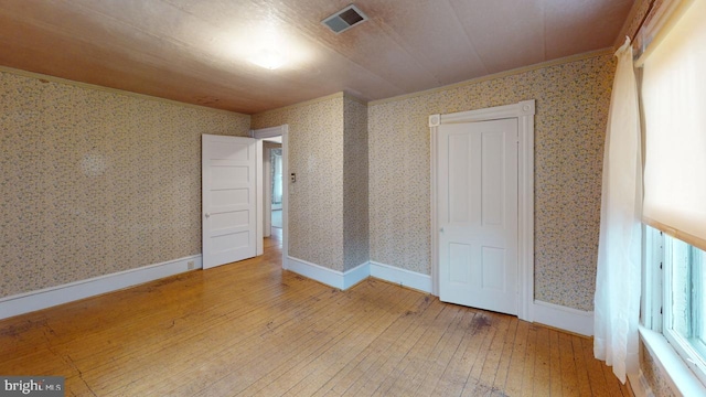 unfurnished bedroom featuring hardwood / wood-style flooring and ornamental molding