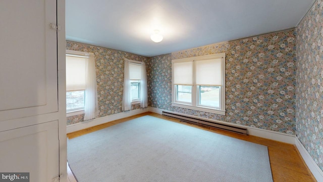 spare room with a baseboard radiator and wood-type flooring