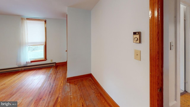 hall with light wood-type flooring and baseboard heating