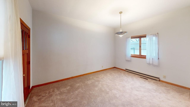 carpeted spare room featuring baseboard heating