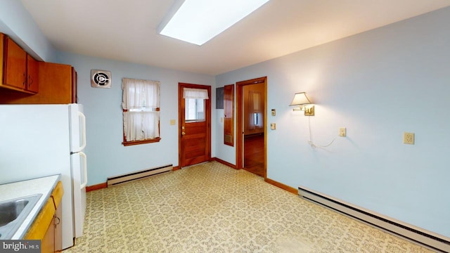 kitchen featuring a baseboard radiator and white fridge